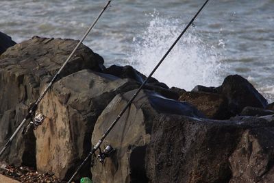 High angle view of fishing net on rock by sea