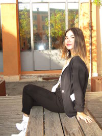 Portrait of smiling young woman sitting outdoors