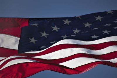 Low angle view of flag against blue sky