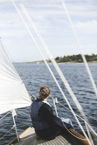 Woman sitting in sailboat on sunny day