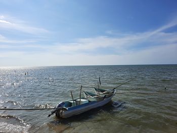 Boats moored in sea against sky