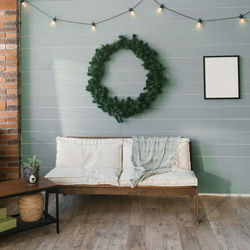 Christmas wreath over the sofa in the living room in scandinavian minimalist style