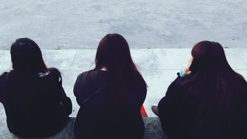 Rear view of women standing on floor