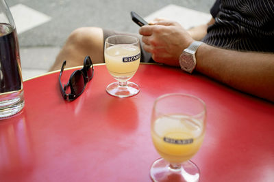 Midsection of woman with wineglass on table in restaurant