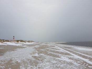 Scenic view of beach against sky during winter