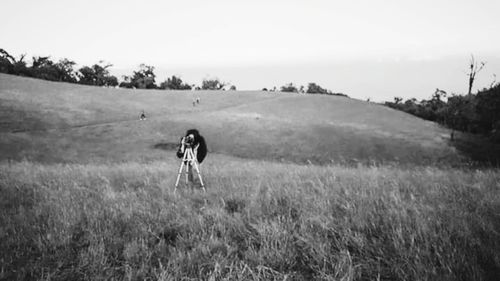 Woman standing on field against sky