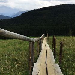 Wooden fence on field against sky