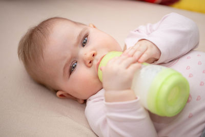 Portrait of cute baby lying on bed