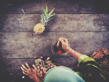 Directly above shot of woman preparing food on wooden floor