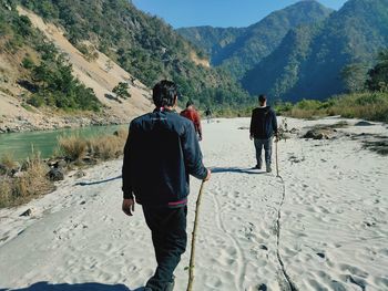 Rear view of people walking on land