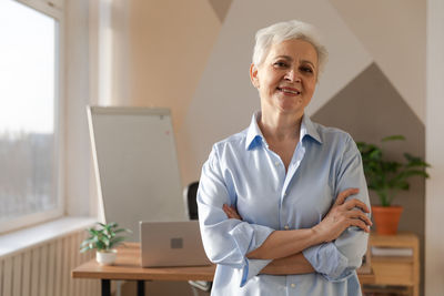 Portrait of young woman standing in office