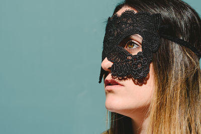 Woman wearing eye mask against blue background