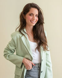 Portrait of young woman standing against white background
