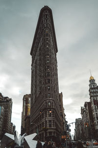 Low angle view of buildings against cloudy sky