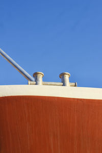 Low angle view of wall against clear blue sky