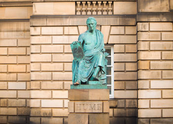 Low angle view of statue against brick wall
