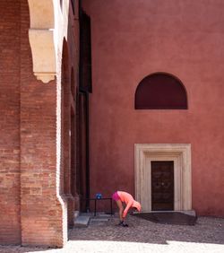 Woman walking by red door