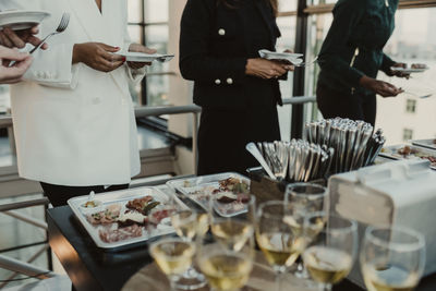 Midsection of business people having meal during company party