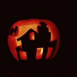 Close-up of illuminated lamp over black background
