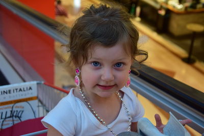 Portrait of cute girl sitting in shopping cart