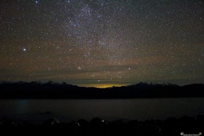 Scenic view of mountains against sky at night