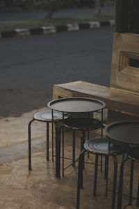 Empty chairs and tables at sidewalk cafe