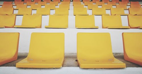 Close-up of yellow chairs in row