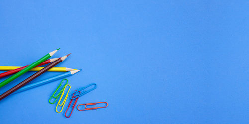High angle view of colored pencils on blue background
