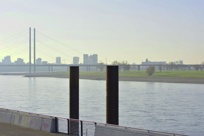 Bridge over river in city against clear sky