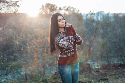 Young woman standing on field in forest