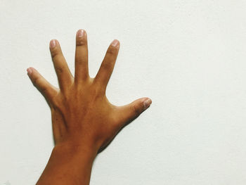 Close-up of hand against wall