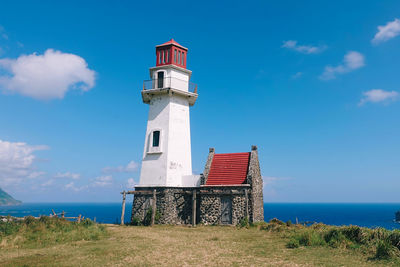 Lighthouse by sea against sky