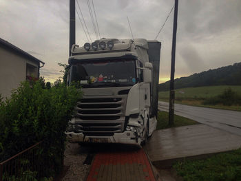 Cars on road against cloudy sky