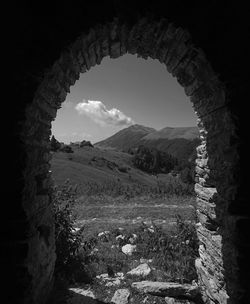 Scenic view of field against sky seen through arch