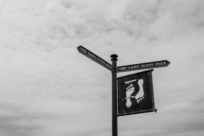 Low angle view of information sign against sky