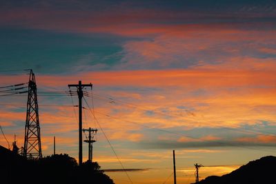 Low angle view of silhouette electricity pylon against sky during sunset