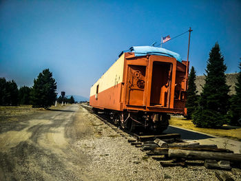 Train on railroad track against clear blue sky