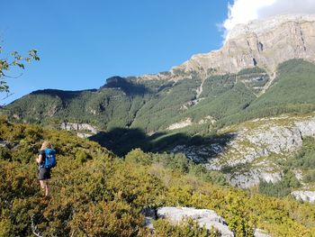 Rear view of man on mountain against sky