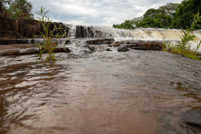 Scenic view of waterfall against sky