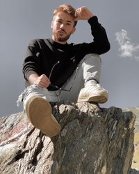 Portrait of young man sitting on rock