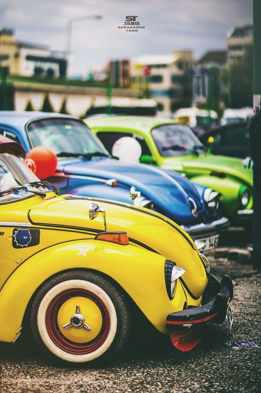 transportation, mode of transport, land vehicle, car, yellow, focus on foreground, stationary, travel, street, close-up, outdoors, day, on the move, vehicle, no people, parking, road, selective focus, parking lot, toy