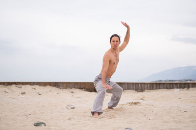 Full length of shirtless man practicing martial arts
