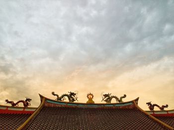 Low angle view of building on roof against sky