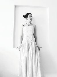 Portrait of woman standing against white background