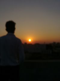 Silhouette man standing against sky during sunset