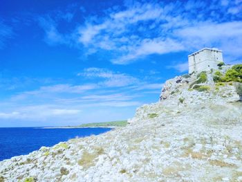 Scenic view of sea by buildings against sky