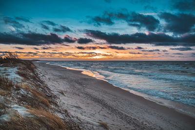 Scenic view of beach against sky during sunset