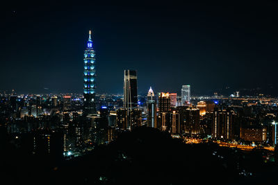 Illuminated cityscape against sky at night