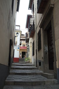 Low angle view of stairs amidst buildings in city