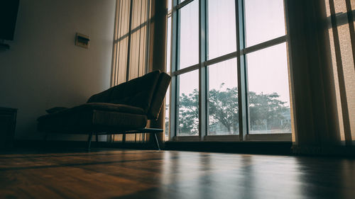 Empty sofa in living room against window at home
